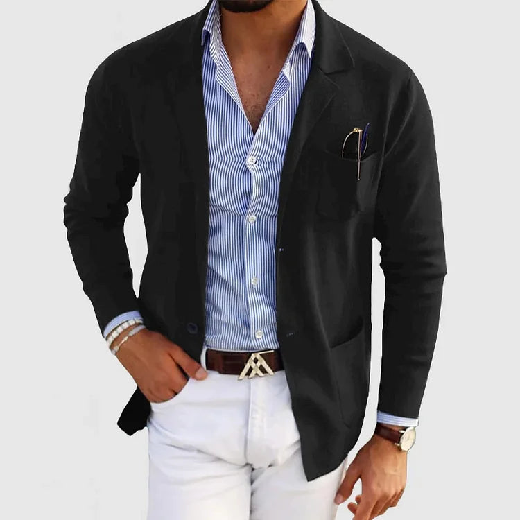 Uomo con giacca nera elegante, camicia a righe blu e pantaloni bianchi. Moda maschile, abbigliamento casual chic, stile moderno.