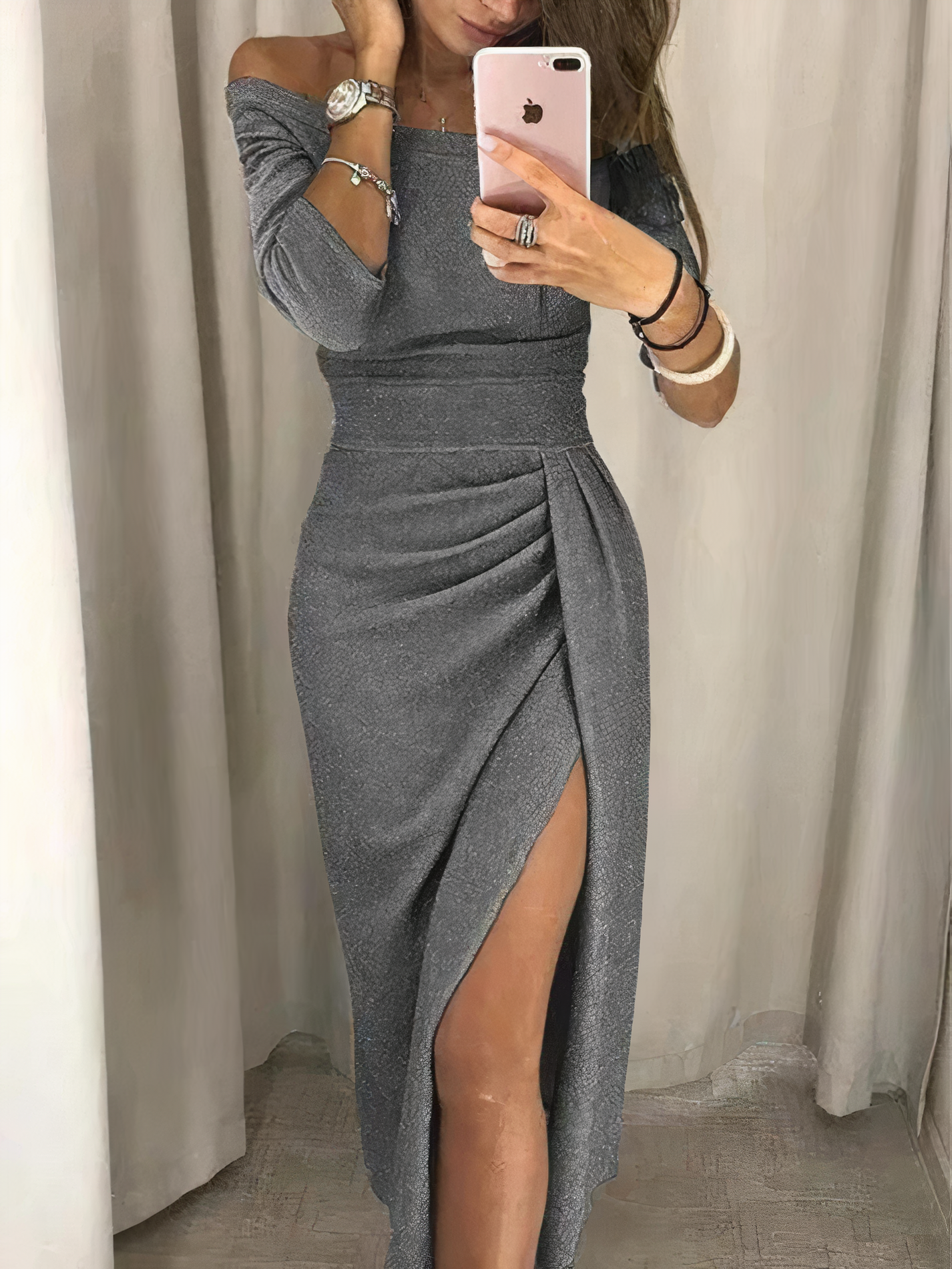 Donna in abito lungo grigio con spacco, scatta selfie allo specchio. Moda elegante, abbigliamento da sera, stile sofisticato.