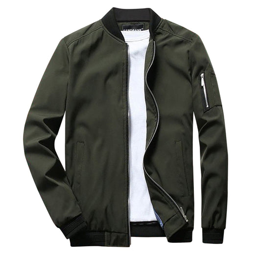 Giacca bomber verde oliva da uomo con zip, tasca sulla manica e polsini a coste, indossata sopra una maglietta bianca. Moda casual maschile.