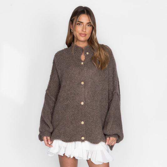 Women's oversized chunky-knit cardigan with gold buttons, a high collar, and balloon sleeves.