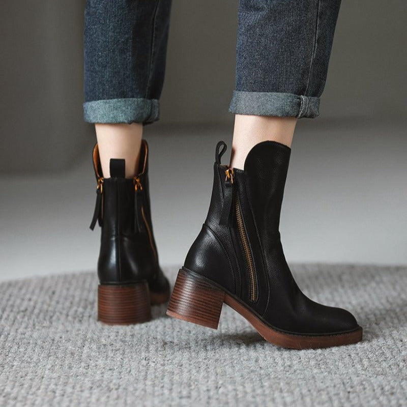 Stivaletti neri in pelle con tacco largo, zip laterale dorata, indossati con jeans risvoltati. Scarpe moda autunno inverno donna.