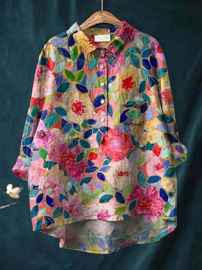 Camicia floreale colorata su sfondo scuro, con motivi di fiori e foglie vivaci. Moda donna, abbigliamento casual, stile primaverile.