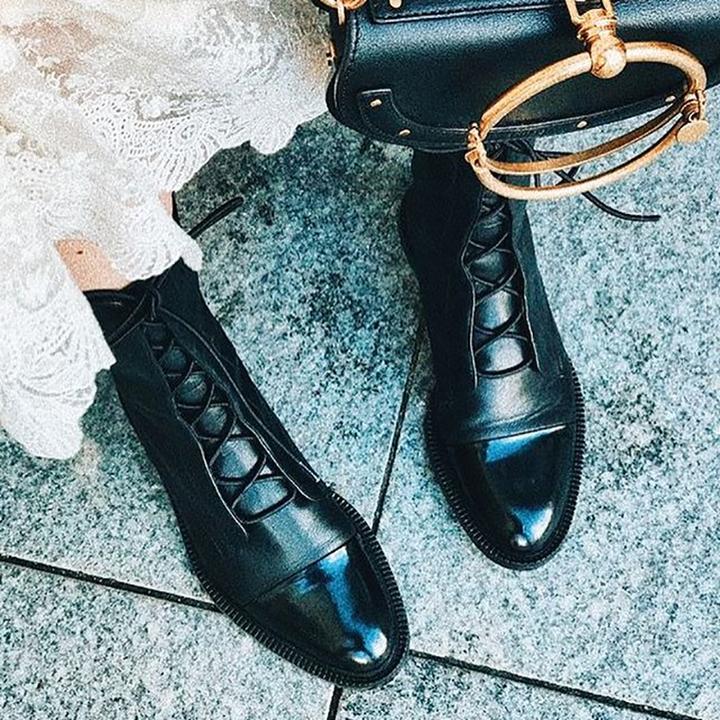 Women's mid-calf lace-up boots with a flat sole and British-inspired design.