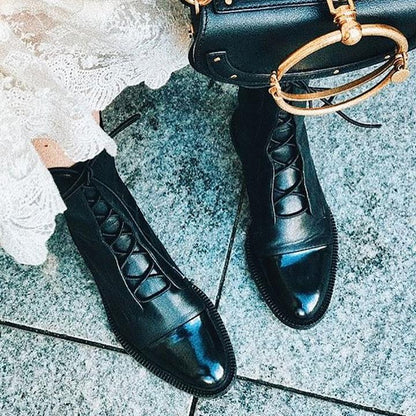 Women's mid-calf lace-up boots with a flat sole and British-inspired design.