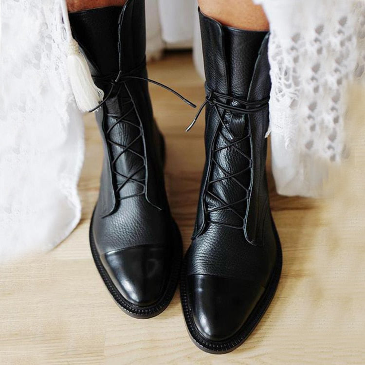 Women's mid-calf lace-up boots with a flat sole and British-inspired design.
