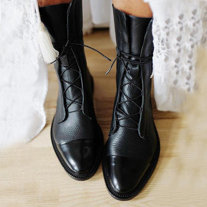 Women's mid-calf lace-up boots with a flat sole and British-inspired design.