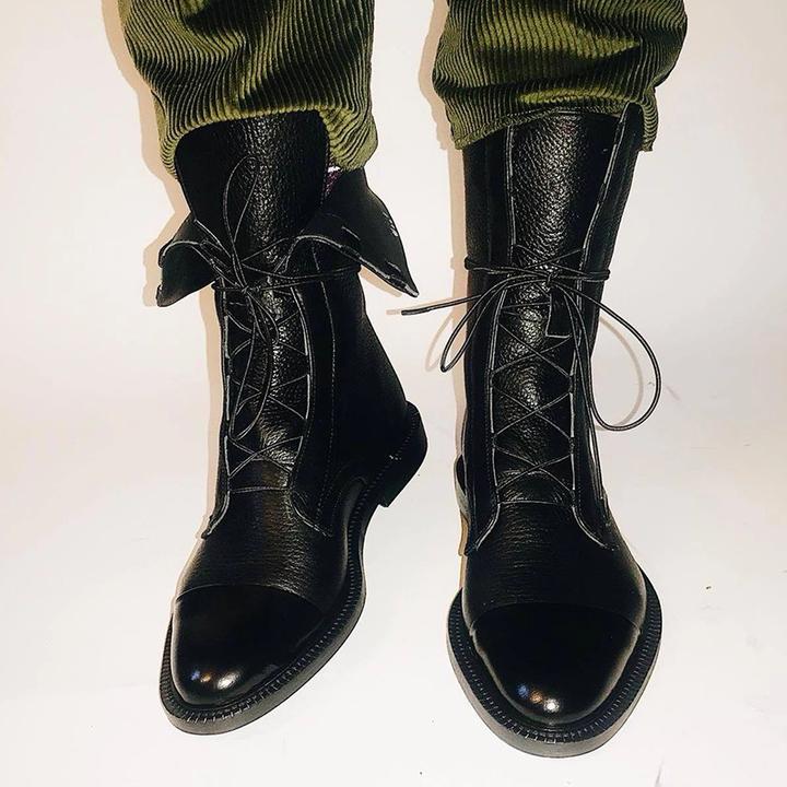 Women's mid-calf lace-up boots with a flat sole and British-inspired design.
