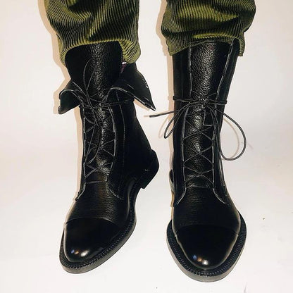 Women's mid-calf lace-up boots with a flat sole and British-inspired design.