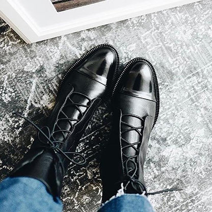 Women's mid-calf lace-up boots with a flat sole and British-inspired design.