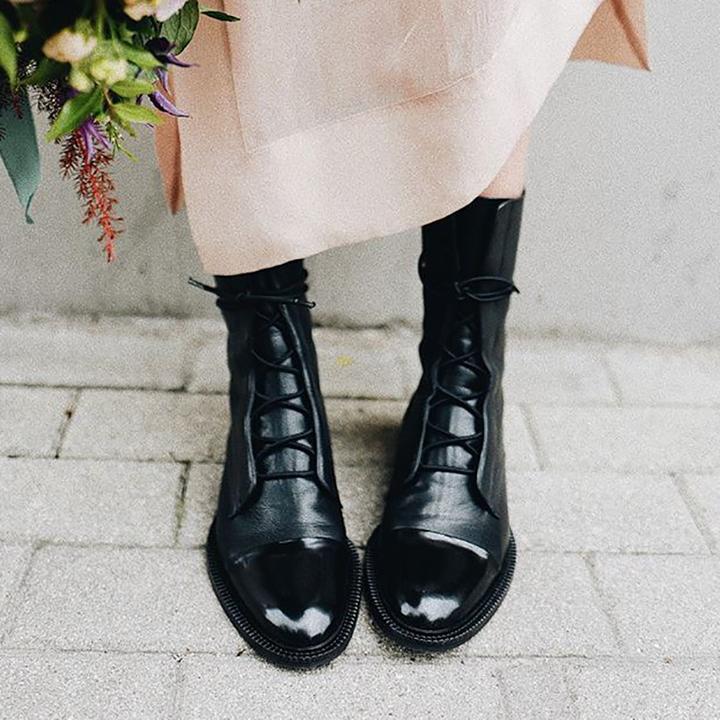 Women's mid-calf lace-up boots with a flat sole and British-inspired design.