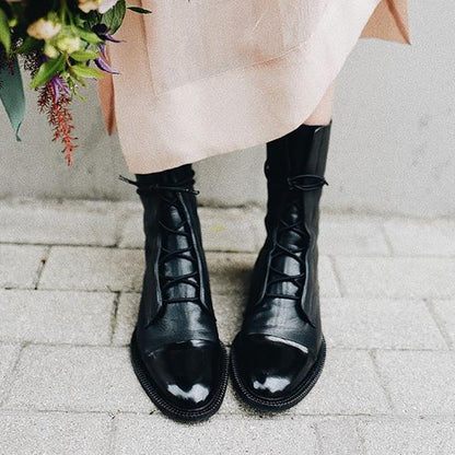 Women's mid-calf lace-up boots with a flat sole and British-inspired design.