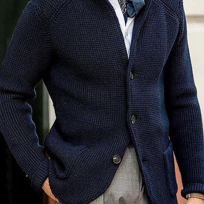 Giacca blu scuro in maglia, abbinata a camicia bianca e cravatta, stile elegante maschile. Look autunnale, moda uomo sofisticata.