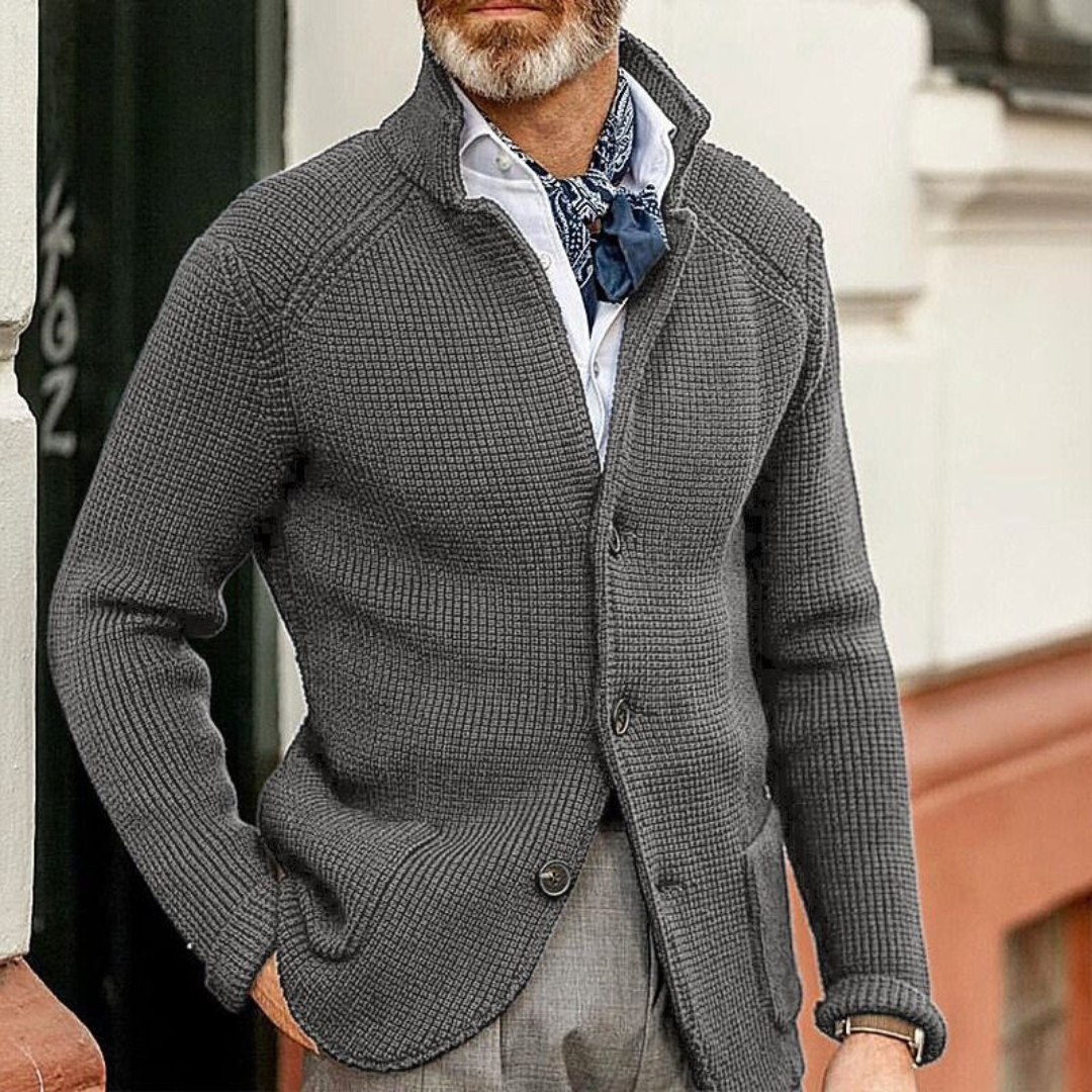 Uomo con cardigan grigio a maglia grossa, camicia bianca e foulard blu. Moda maschile elegante, abbigliamento autunnale casual chic.