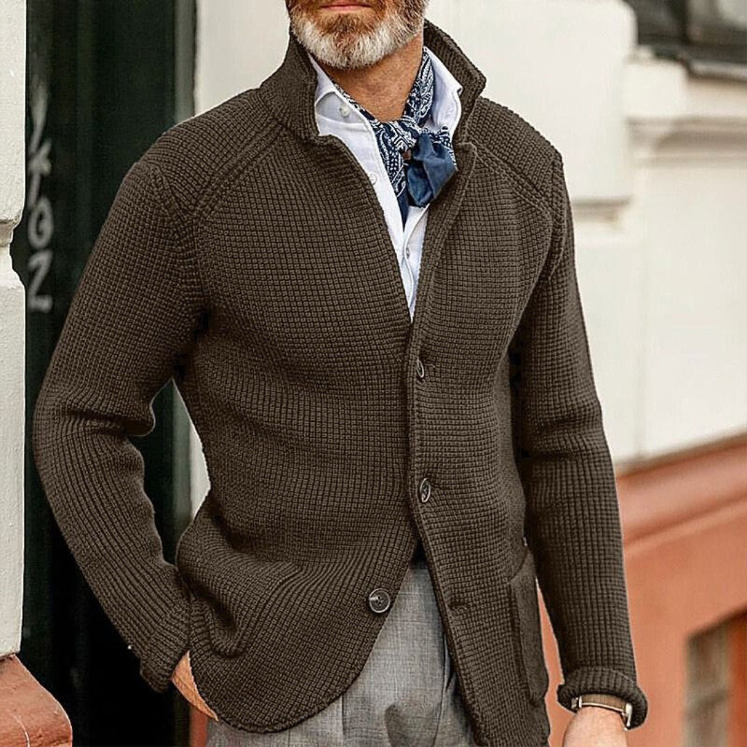 Giacca cardigan marrone uomo, tessuto a maglia, abbinata a camicia bianca e foulard blu. Moda maschile autunnale elegante e casual.