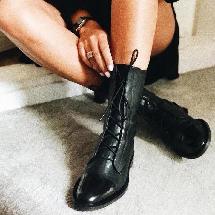 Women's mid-calf lace-up boots with a flat sole and British-inspired design.