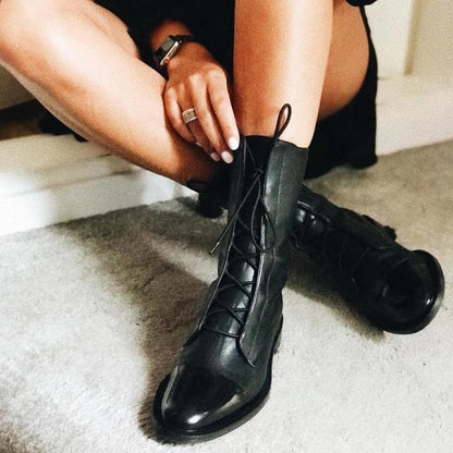 Women's mid-calf lace-up boots with a flat sole and British-inspired design.