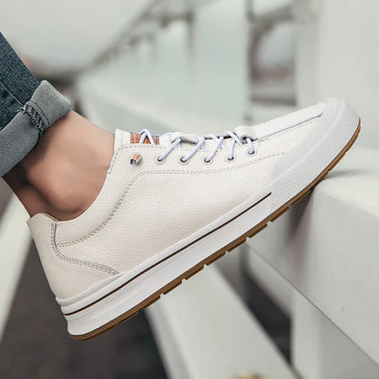 Scarpe da ginnastica bianche eleganti, suola in gomma marrone, lacci bianchi, indossate con jeans. Scarpe casual uomo, moda urbana.