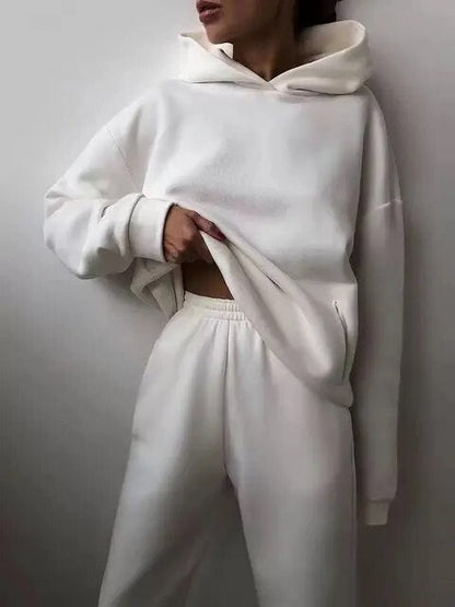 Donna in tuta bianca, felpa con cappuccio e pantaloni, moda casual, abbigliamento comodo, stile minimalista, outfit monocromatico.