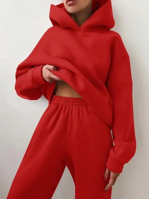 Donna in tuta rossa con cappuccio, moda casual, abbigliamento sportivo, stile urbano, comfort e tendenza, abbigliamento donna autunno inverno.