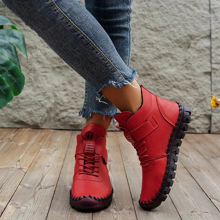 Jeans attillati e stivaletti rossi in pelle su pavimento in legno, moda casual donna, scarpe autunnali, stile urbano, comfort e tendenza.