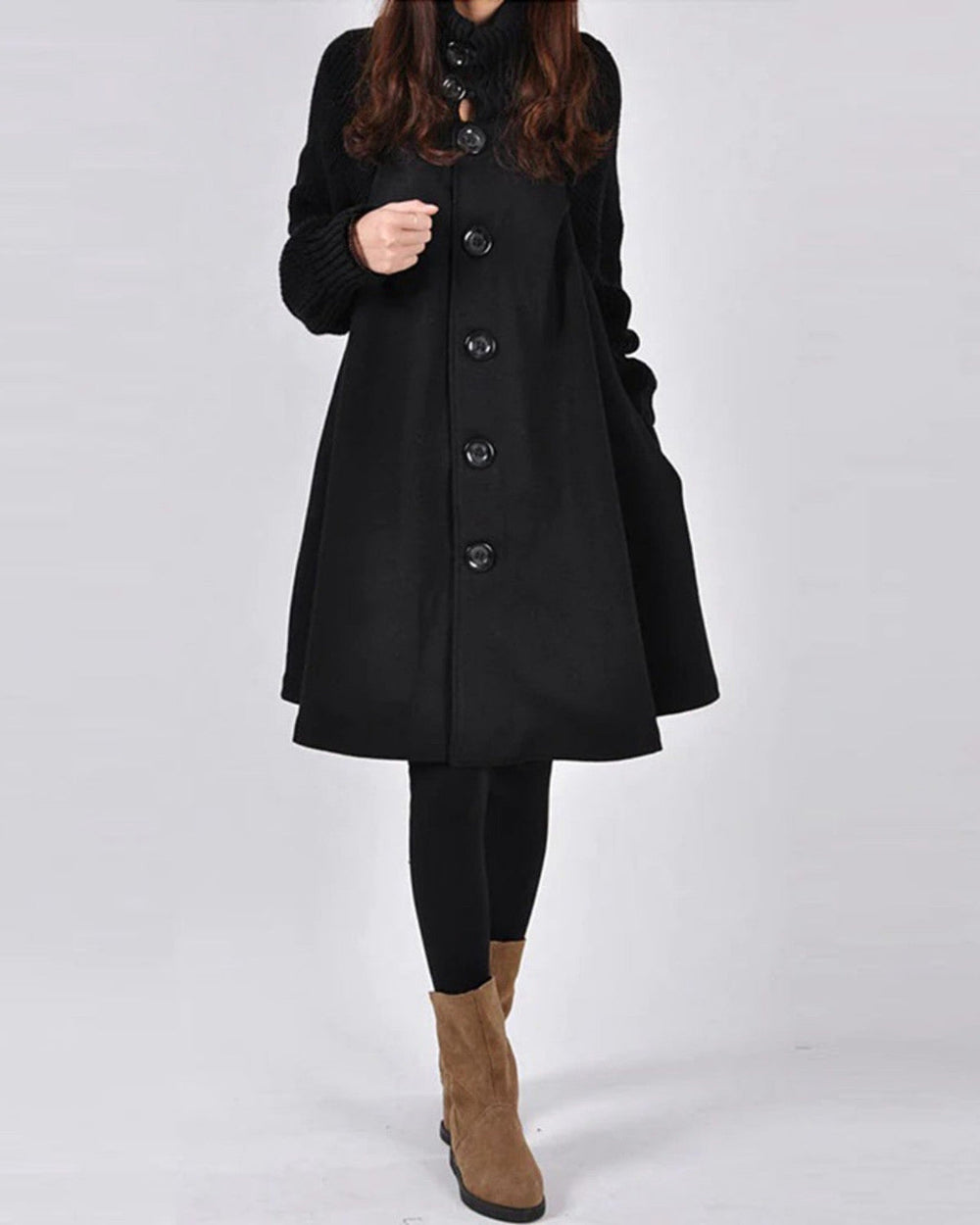 Cappotto nero elegante con bottoni grandi, maniche lunghe, abbinato a leggings neri e stivali marroni. Moda autunnale donna, stile casual chic.