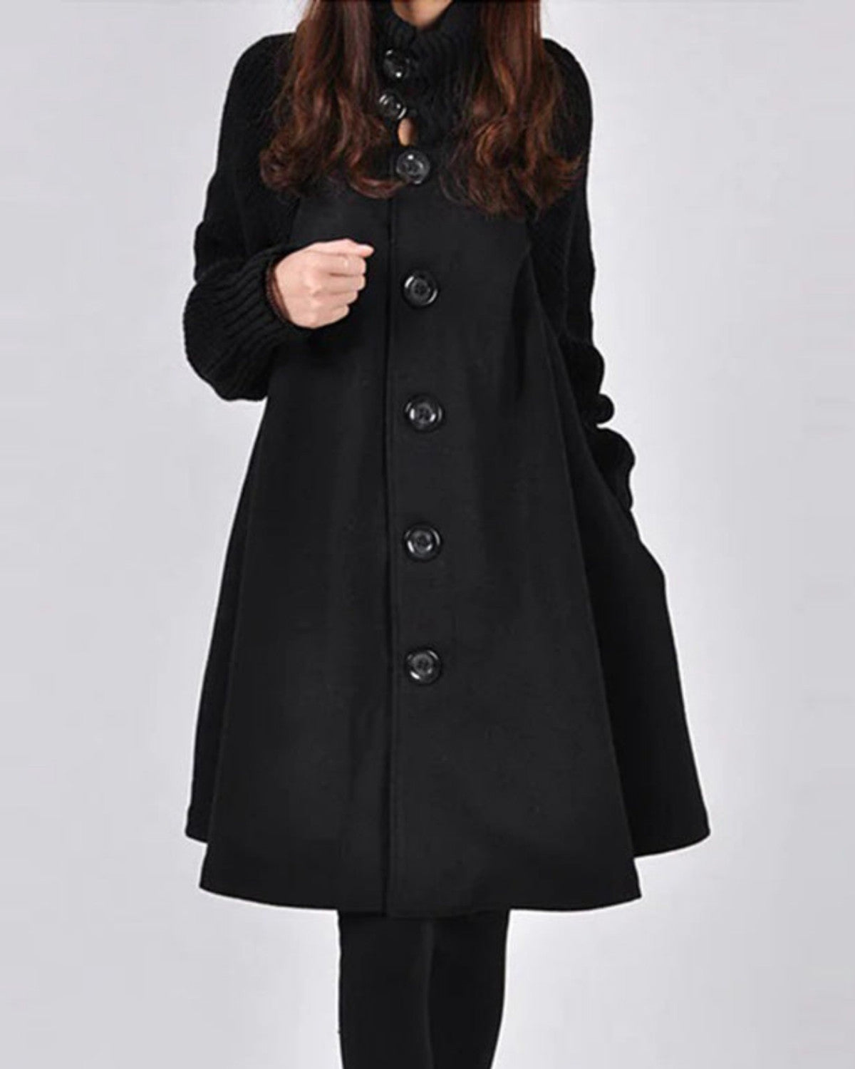 Cappotto nero elegante da donna con bottoni grandi, maniche lunghe, design classico. Moda invernale, abbigliamento femminile chic e sofisticato.