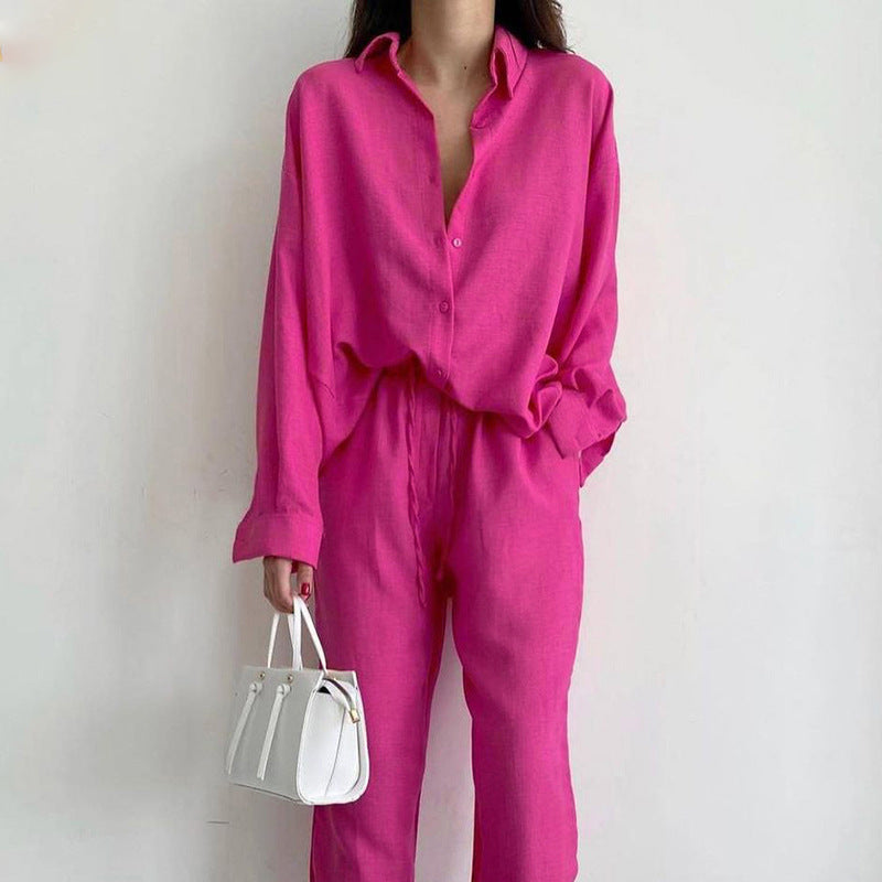 Donna in abito rosa acceso con camicia e pantaloni coordinati, borsa bianca a mano. Moda femminile, stile casual chic, tendenze 2023.
