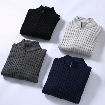Quattro maglioni a collo alto con cerniera, colori nero, grigio, blu e bianco, su sfondo bianco. Maglioni invernali, moda uomo, abbigliamento casual.