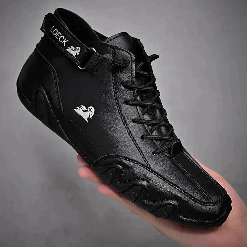 Scarpa sportiva nera in pelle con logo bianco, design moderno e lacci, tenuta in mano. Calzatura elegante e confortevole per uomo.