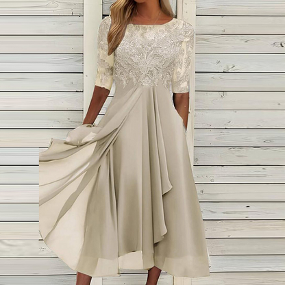 Abito elegante donna beige, maniche corte in pizzo, gonna fluida, sfondo legno chiaro. Moda femminile, abbigliamento cerimonia, stile sofisticato.