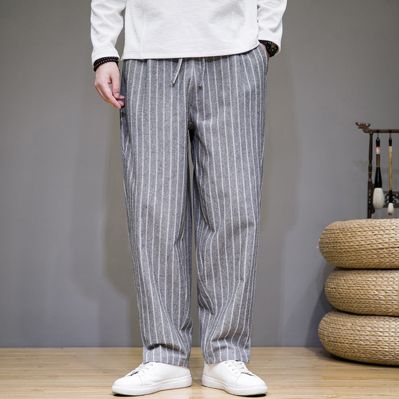 Pantaloni a righe grigie da uomo, stile casual, abbinati a scarpe bianche. Moda maschile, abbigliamento confortevole, tendenze 2023.