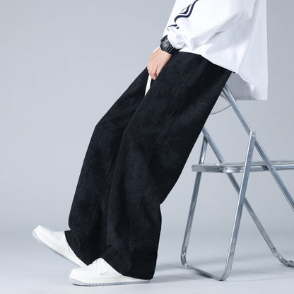 Pantaloni larghi neri uomo, stile casual, indossati con scarpe bianche e camicia bianca, moda streetwear, seduto su sedia pieghevole.