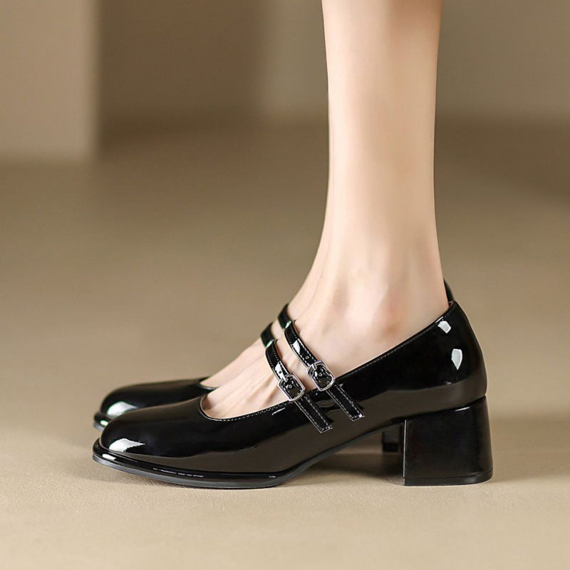 Scarpe nere lucide con tacco medio e doppio cinturino, eleganti e alla moda, ideali per abbigliamento formale o casual chic.