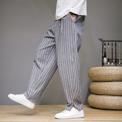 Pantaloni a righe grigie da uomo, stile casual, abbinati a scarpe bianche. Moda maschile, abbigliamento estivo, look rilassato.