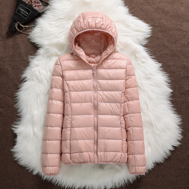 Giacca invernale rosa con cappuccio su sfondo di pelliccia bianca, design trapuntato, moda donna, abbigliamento caldo, stile casual elegante.