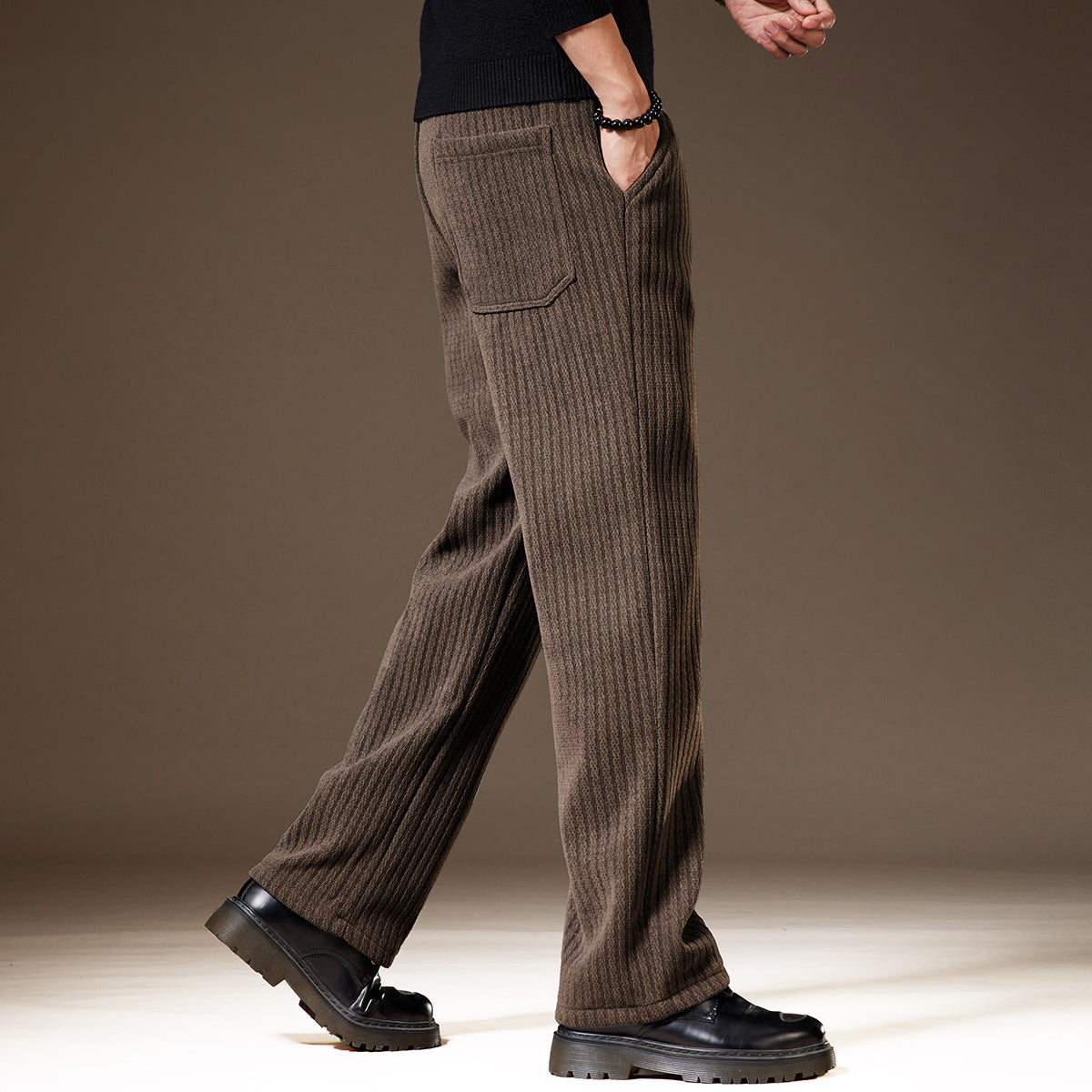 Pantaloni uomo marroni a coste, stile casual, con tasche laterali. Indossati con scarpe nere eleganti. Moda autunnale, abbigliamento maschile.