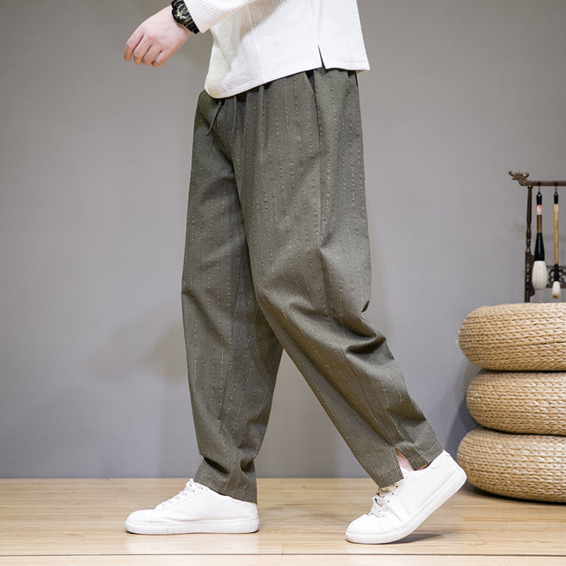 Pantaloni larghi verdi da uomo, stile casual, con scarpe bianche su sfondo grigio. Moda maschile, abbigliamento confortevole, tendenze 2023.