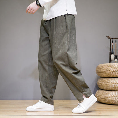 Pantaloni larghi verdi da uomo, stile casual, con scarpe bianche su sfondo grigio. Moda maschile, abbigliamento confortevole, tendenze 2023.