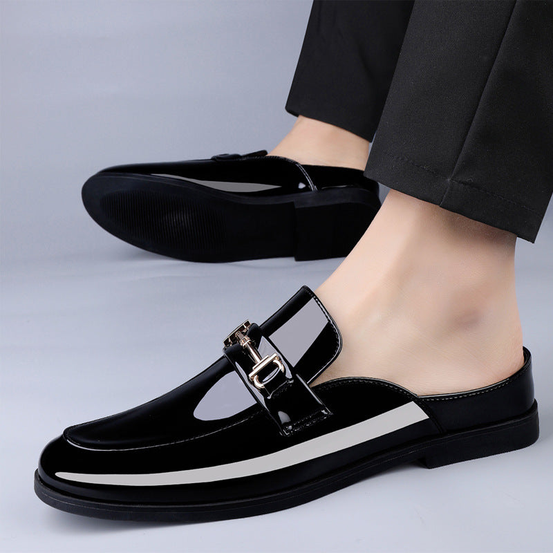 Scarpe mocassini uomo in pelle nera lucida con fibbia metallica, indossate con pantaloni eleganti. Calzature moda maschile, stile classico e raffinato.