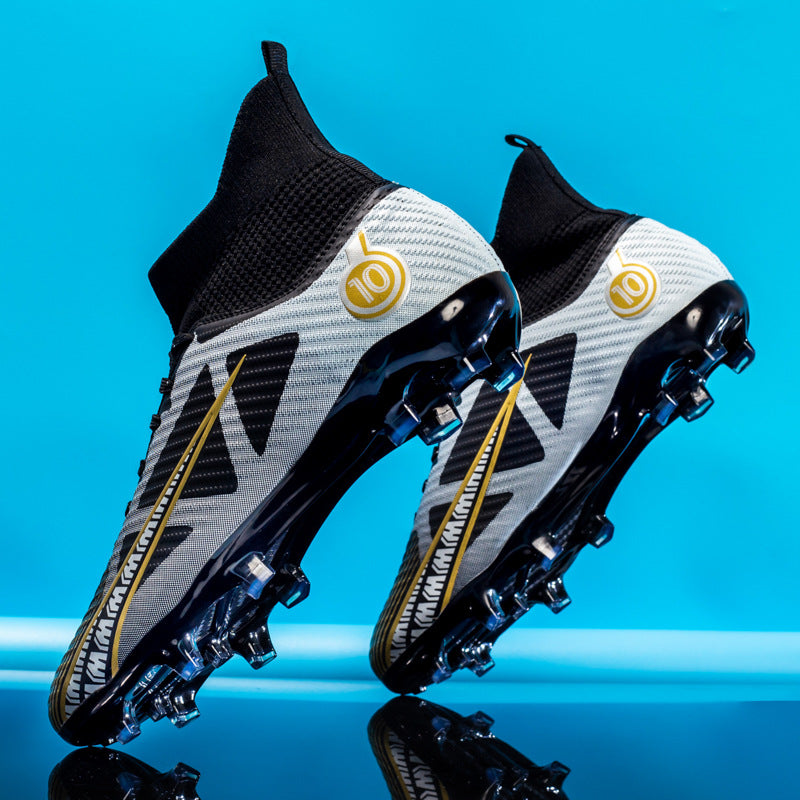Scarpe da calcio bianche e nere con dettagli dorati, design moderno, suola con tacchetti, sfondo blu. Ideali per prestazioni sportive elevate.