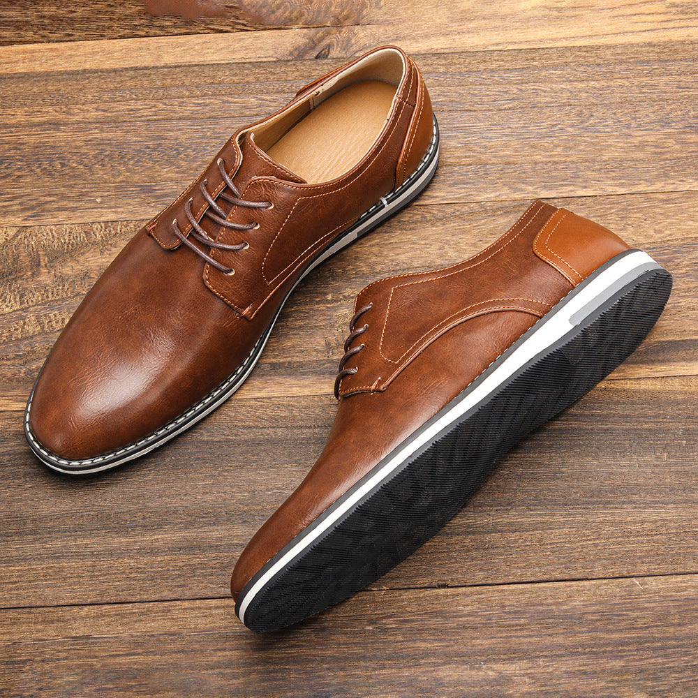 Scarpe eleganti da uomo in pelle marrone su sfondo di legno, suola antiscivolo nera, design classico, ideali per abbigliamento formale e casual.