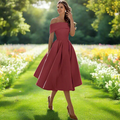 Donna in abito rosso elegante, stile vintage, cammina in un giardino fiorito. Moda femminile, abbigliamento estivo, natura, bellezza.