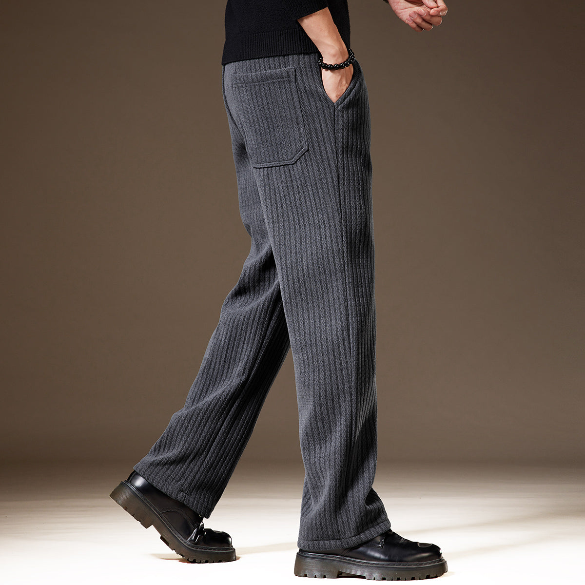 Pantaloni uomo grigi a coste, eleganti e casual, con tasca posteriore, indossati con scarpe nere. Moda maschile autunno inverno.