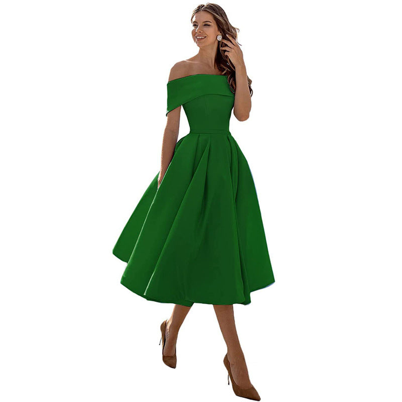 Donna in abito verde elegante, spalle scoperte, gonna ampia, tacchi marroni. Moda femminile, abbigliamento da sera, stile sofisticato.