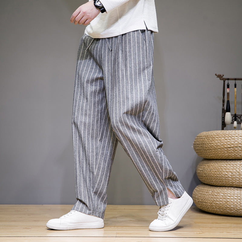 Pantaloni a righe grigie da uomo, stile casual, abbinati a scarpe bianche. Moda maschile moderna, abbigliamento comodo e trendy.