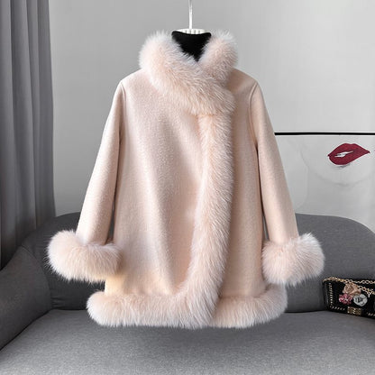 Cappotto invernale donna in lana rosa con bordo in pelliccia sintetica, elegante e caldo, su divano grigio. Moda femminile, abbigliamento autunnale.