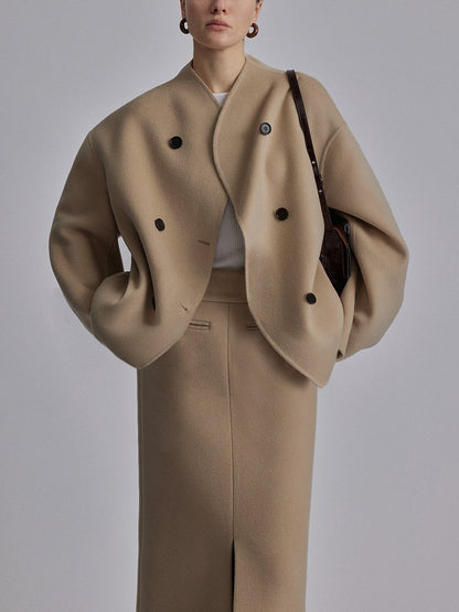 Donna con cappotto oversize beige, abbinato a gonna lunga coordinata. Moda autunno inverno, stile elegante e minimalista.
