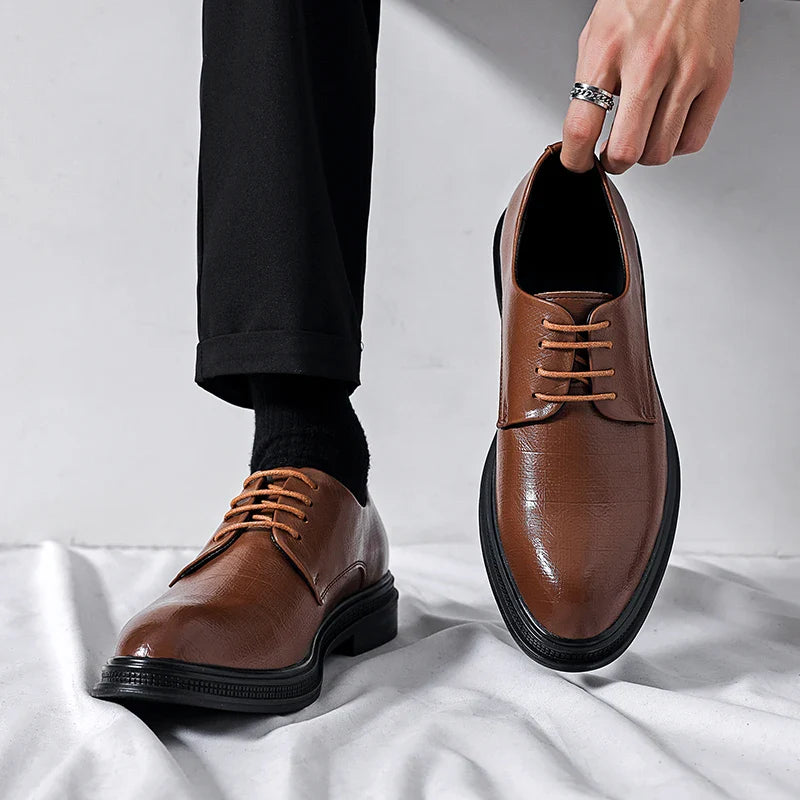 Scarpe eleganti in pelle marrone con lacci, indossate da una persona con pantaloni neri. Design classico, ideale per abbigliamento formale.