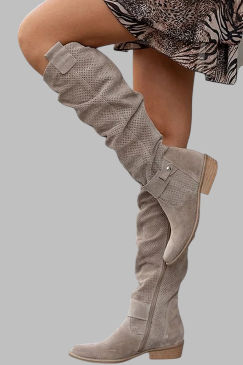 Stivali alti beige in pelle scamosciata, design traforato, tacco basso, abbinati a gonna animalier. Moda autunno, calzature eleganti donna.
