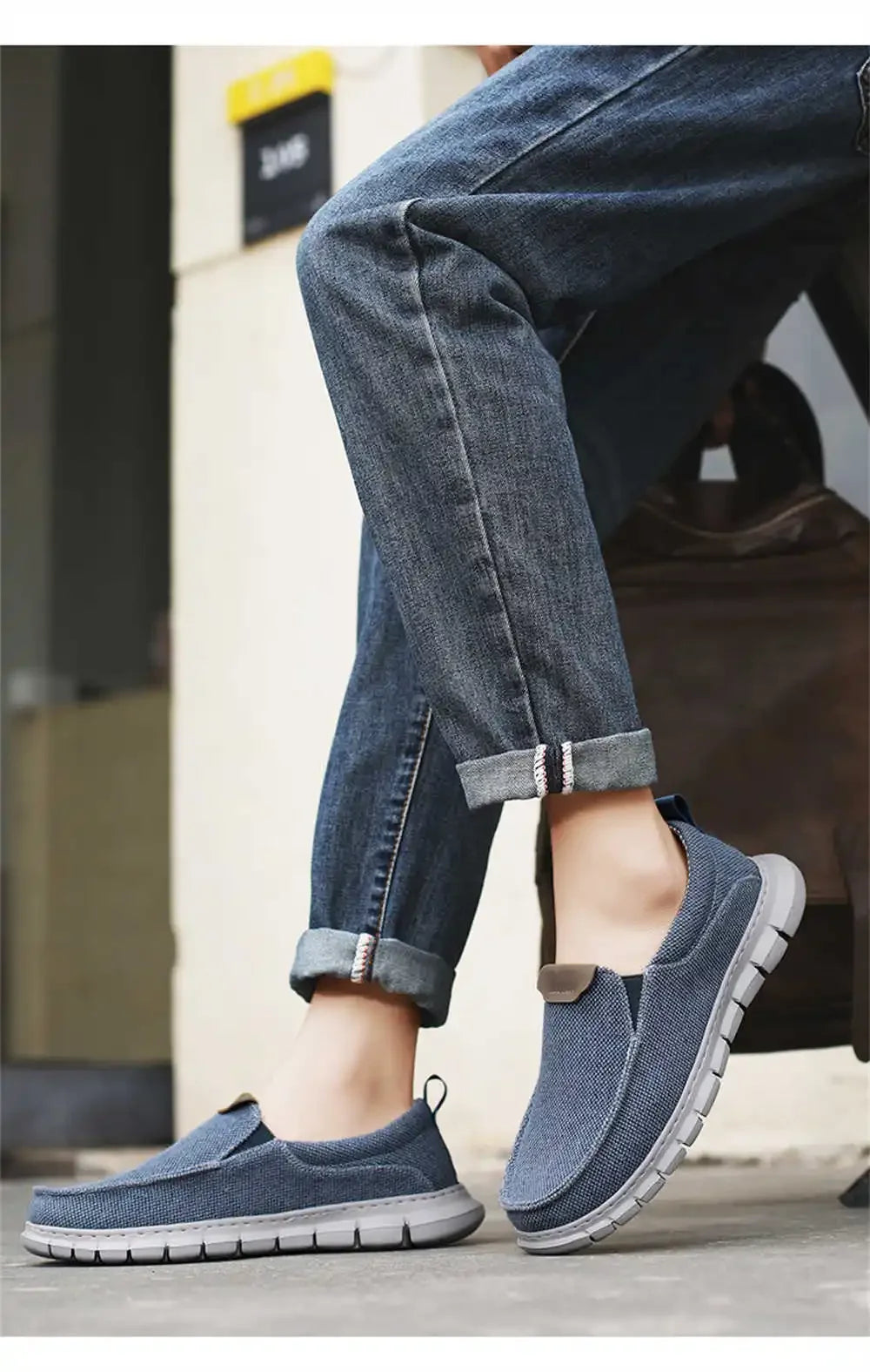 Scarpe slip-on casual blu in tessuto, indossate con jeans arrotolati. Calzature comode e moderne per uno stile urbano e rilassato.